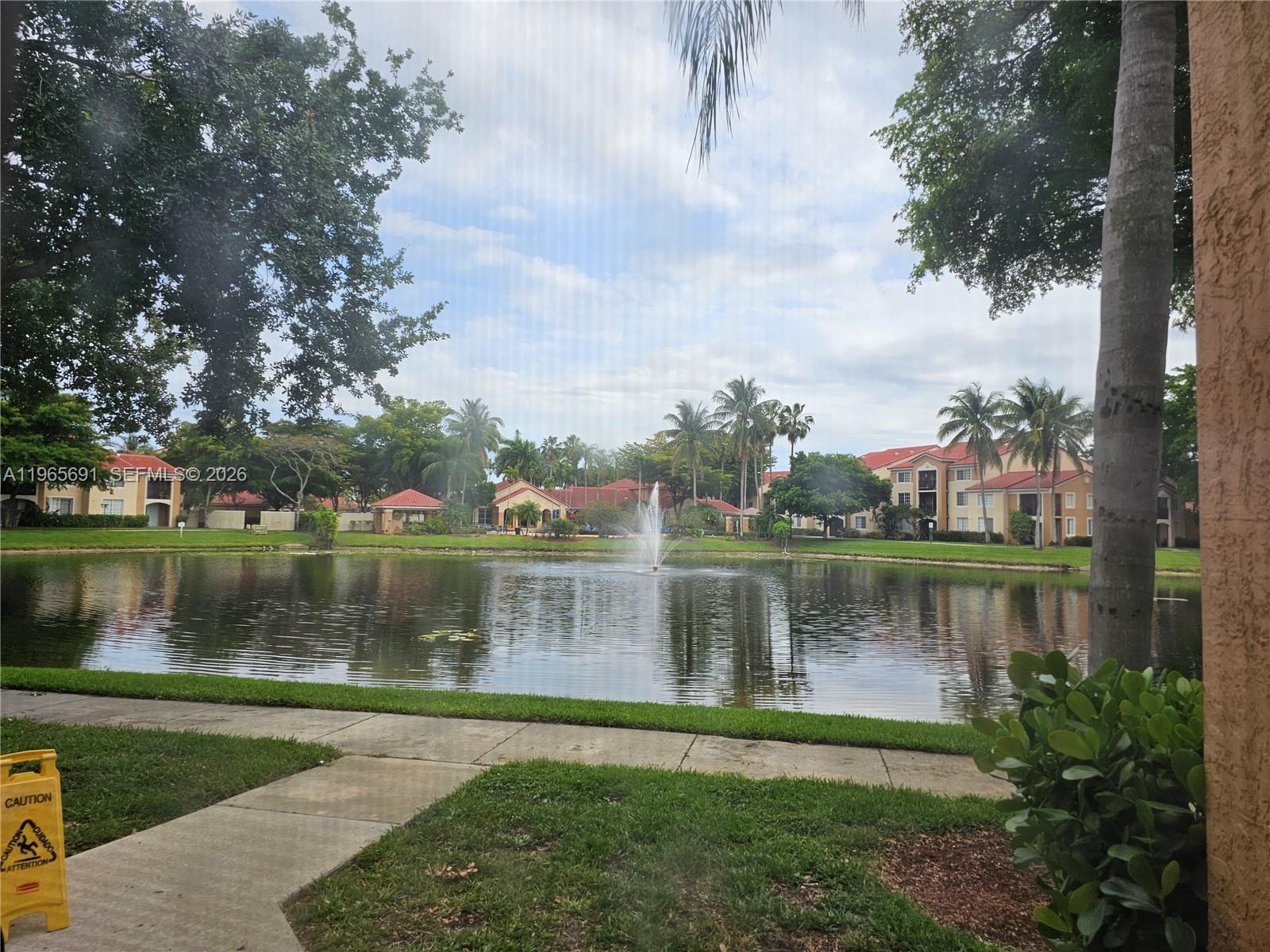 2051 Renaissance Boulevard, Unit 104 Miramar, FL 33025 - Photo 33 of 39 a view of a lake with a yard and large trees