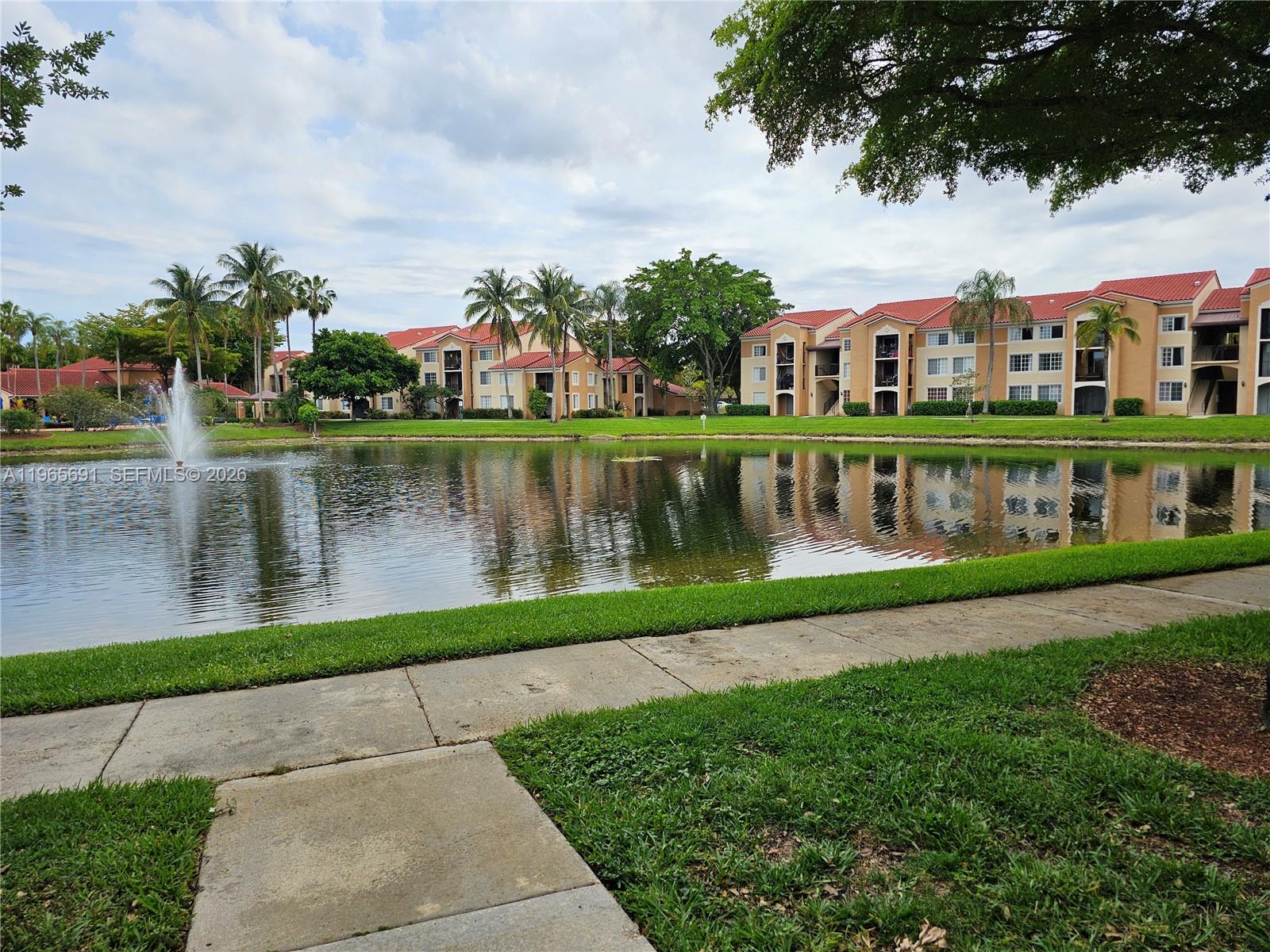 2051 Renaissance Boulevard, Unit 104 Miramar, FL 33025 - Photo 35 of 39 a front view of a house with a garden and lake view