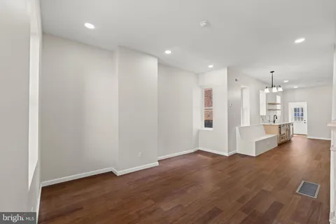 a view of an empty room with wooden floor