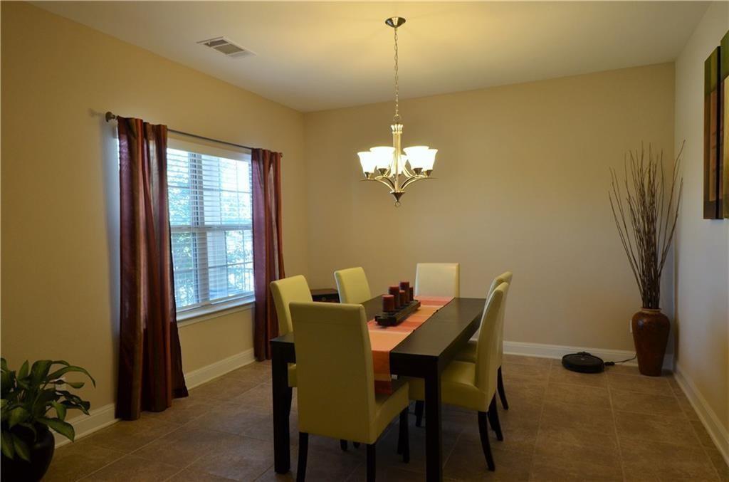 5629 Rio Chama Cove Austin, TX 78738 - Photo 7 of 34 A graceful chandelier illuminates this elegant dining area with tiled flooring and ample natural light.
