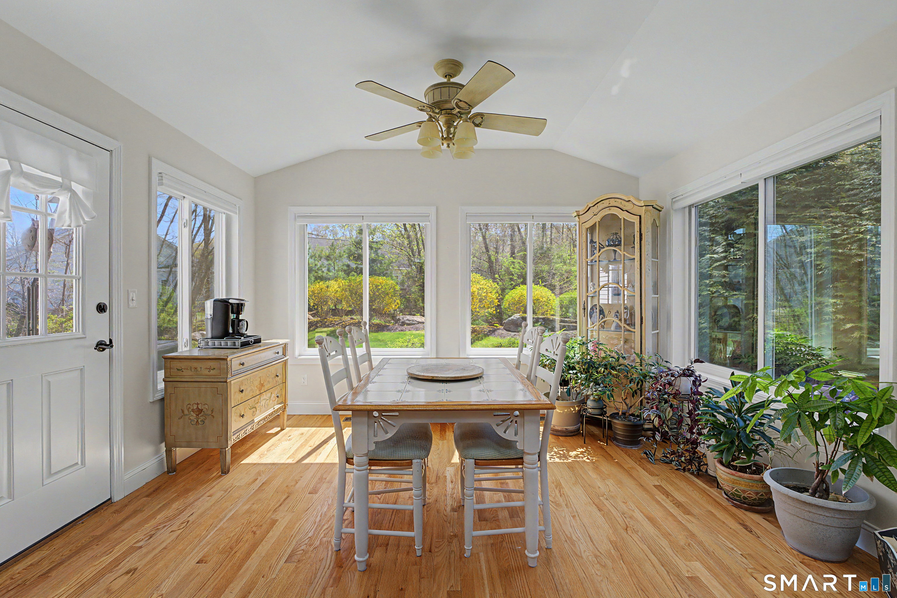 211 Meadowbrook Road, Unit 211 Oxford, CT 06478 - Photo 14 of 38 Enjoy dining surrounded by walls of windows and peaceful greenery-this charming nook blends comfort, light, and nature beautifully.
