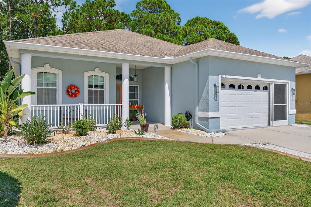 11501 Bloomington Court New Port Richey, FL 34654 - Photo 1 of 71 a front view of a house with a yard outdoor seating and garage