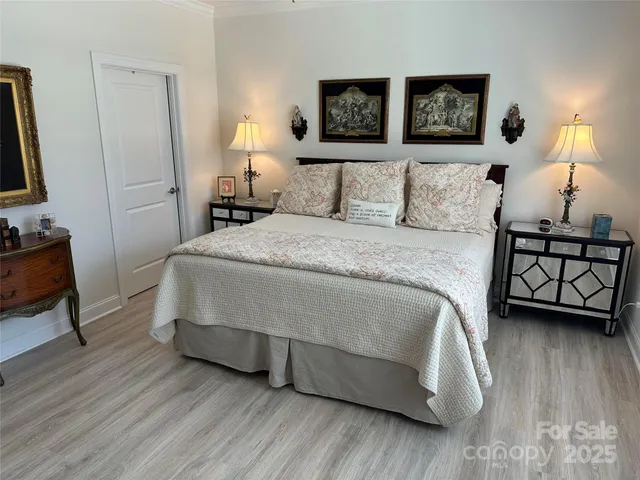 a bedroom with a bed a lamp and a flat screen tv