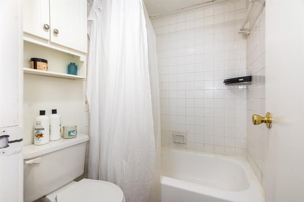 18333 Roehampton Drive, Unit 225 Dallas, TX 75252 - Photo 11 of 13 a white bath tub sitting next to a white toilet and sink