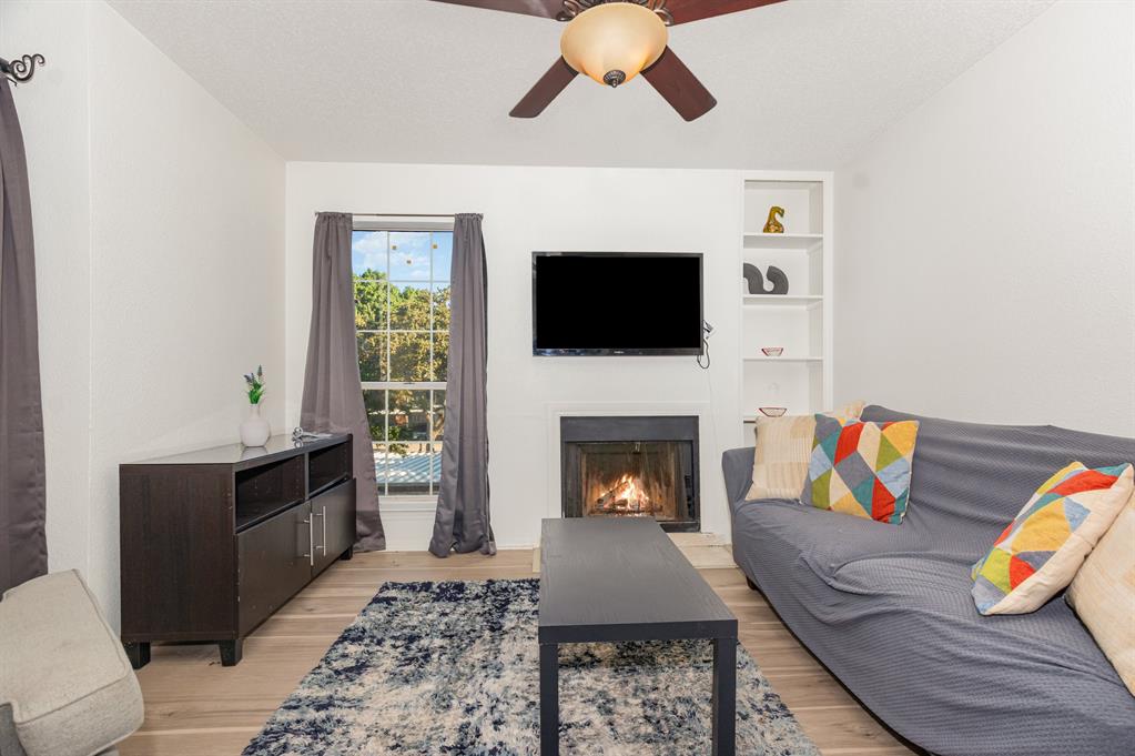 18333 Roehampton Drive, Unit 225 Dallas, TX 75252 - Photo 4 of 13 a living room with furniture and a fireplace