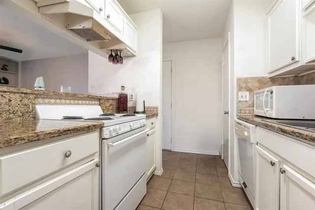a kitchen with a stove top oven and cabinets