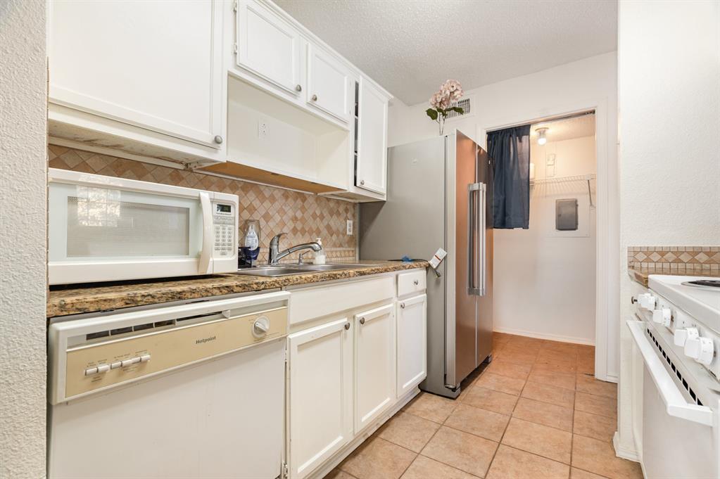18333 Roehampton Drive, Unit 225 Dallas, TX 75252 - Photo 7 of 13 a kitchen with stainless steel appliances a stove and a refrigerator