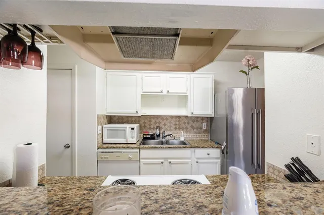 a kitchen with stainless steel appliances kitchen island granite countertop a refrigerator and a stove