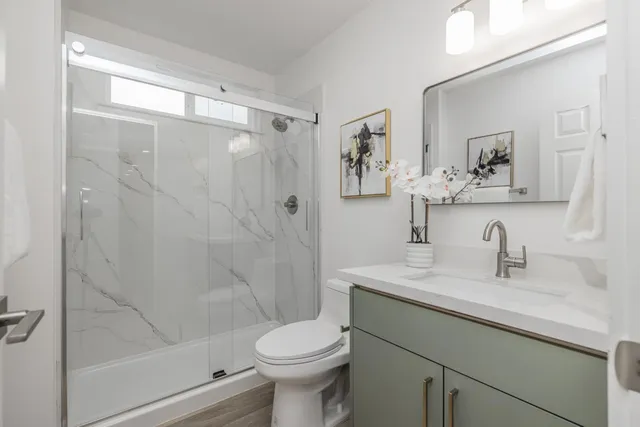 a bathroom with a sink a toilet and shower