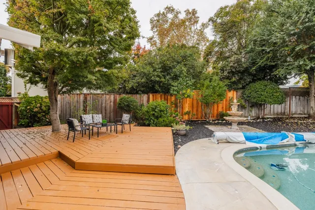 swimming pool with outdoor seating and wooden fence