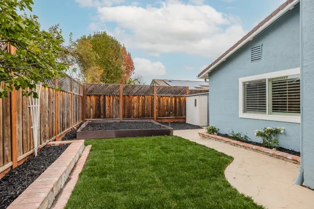 a view of a backyard with table and chairs and wooden fence