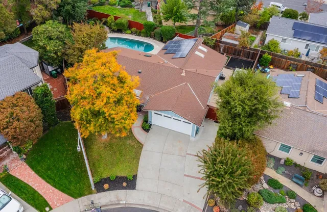 an aerial view of a house with a garden and trees