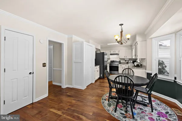 a view of a dining room with furniture and a kitchen