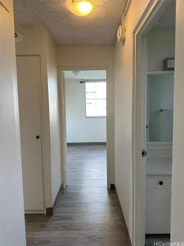 a view of an empty room with wooden floor and closet