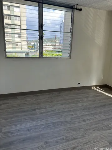 a view of a room with wooden floor and a window
