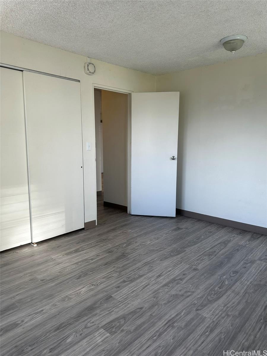 2651 Kuilei Street, Unit B21 Honolulu, HI 96826 - Photo 10 of 20 a view of an empty room with wooden floor and closet