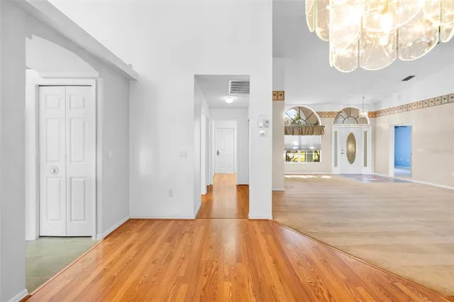 a spacious bedroom with a large bed and a chandelier