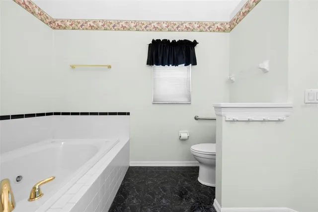 a bathroom with a granite countertop sink mirror vanity and toilet