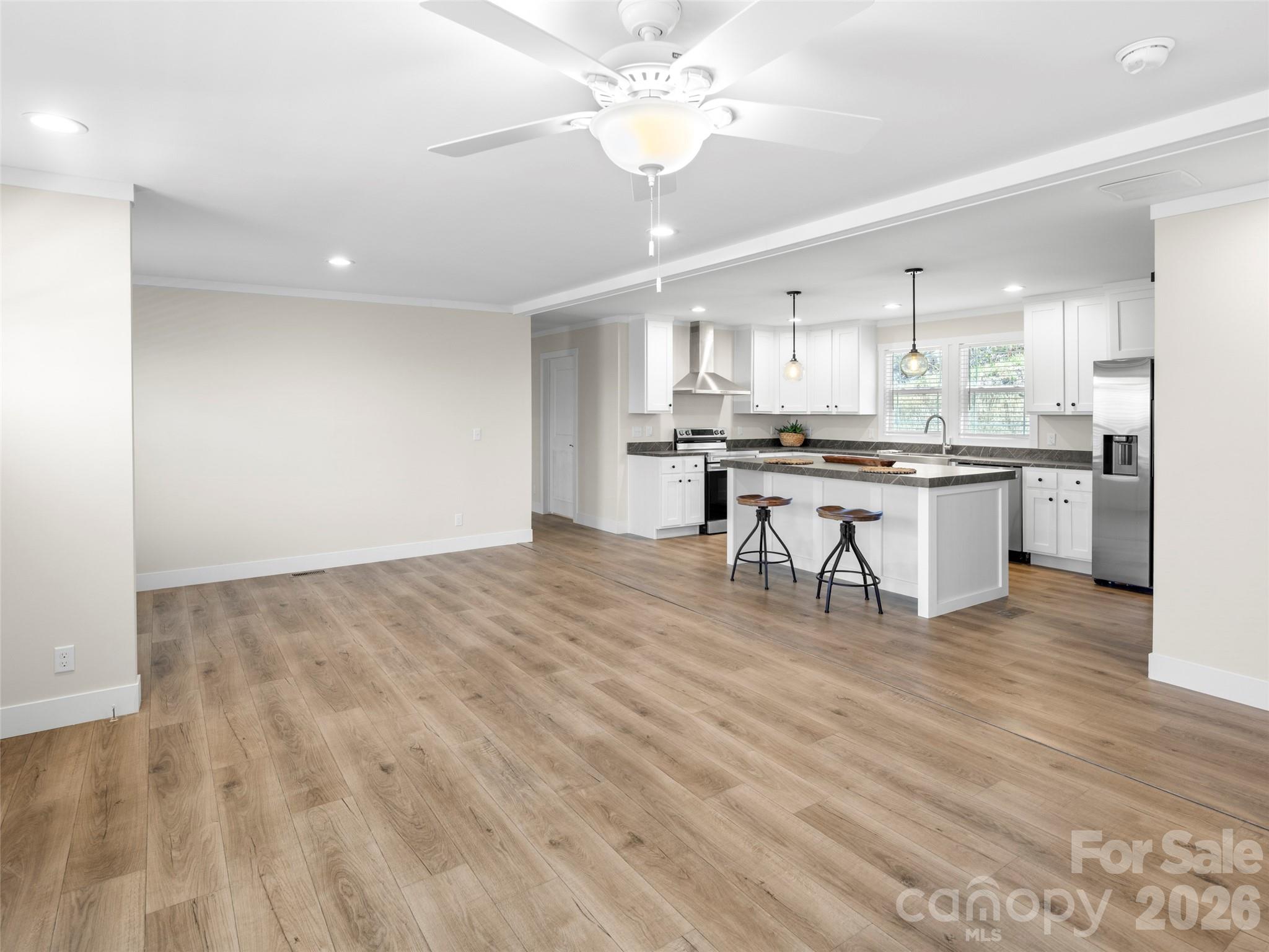 512 Hutch Mountain Road Fletcher, NC 28732 - Photo 9 of 23 a kitchen with stainless steel appliances granite countertop a stove top oven a chimney cabinets and wooden floor