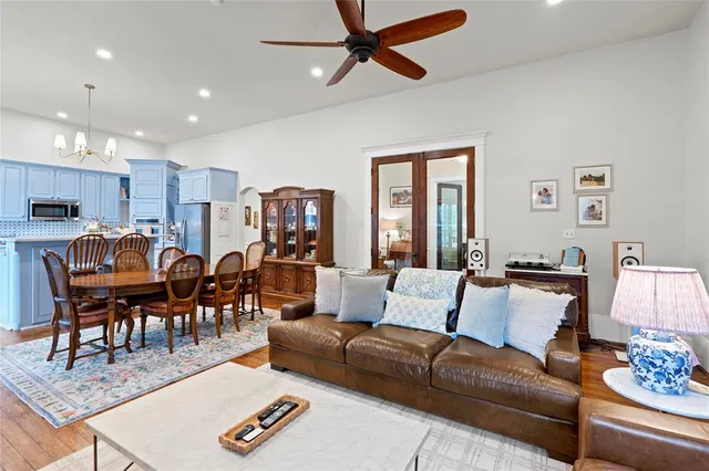 a living room with furniture and a dining table with wooden floor