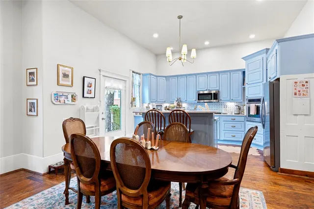 a view of a dining room with furniture a chandelier and wooden floor