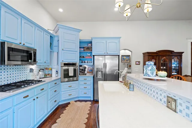 a kitchen with granite countertop a sink a counter top space appliances and cabinets