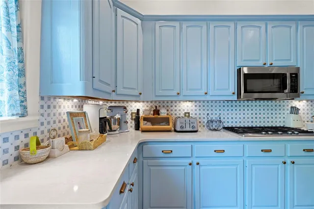 a kitchen with stainless steel appliances a stove a microwave a sink and cabinets