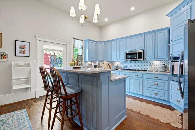 a kitchen with a dining table chairs and refrigerator
