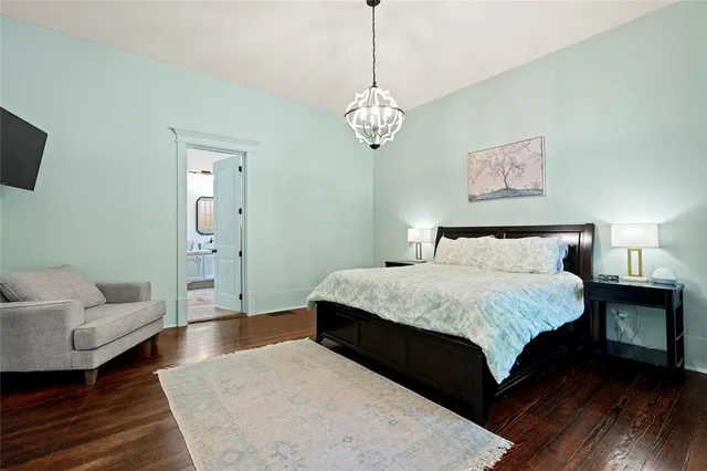 a bedroom with a bed wooden floor and couch