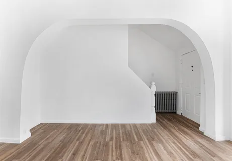 a view of empty room with kitchen and window