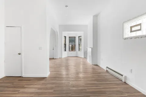 a view of empty room with wooden floor