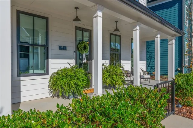 a view of a porch with chairs and potted plants