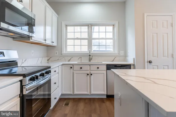 a kitchen with stainless steel appliances a stove a sink and a microwave