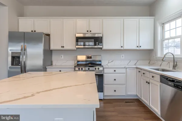 a kitchen with cabinets appliances and a window