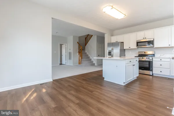 a view of kitchen with wooden floor and electronic appliances