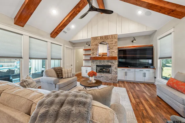 a living room with furniture a flat screen tv and kitchen view