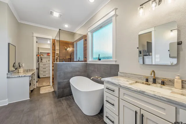 a bathroom with a granite countertop sink mirror and bathtub