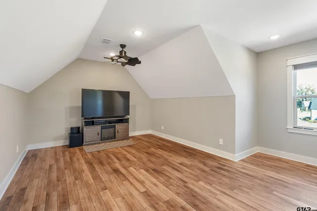 an empty room with windows and flat screen tv