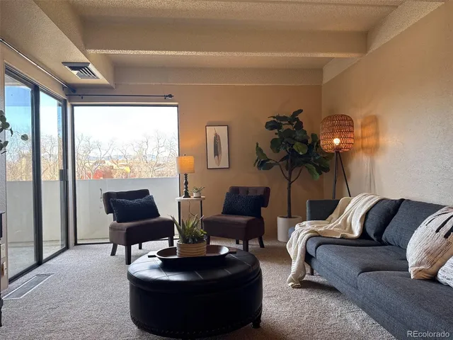 a living room with furniture and a potted plant