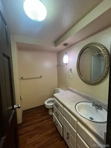 a bathroom with a granite countertop toilet sink and mirror