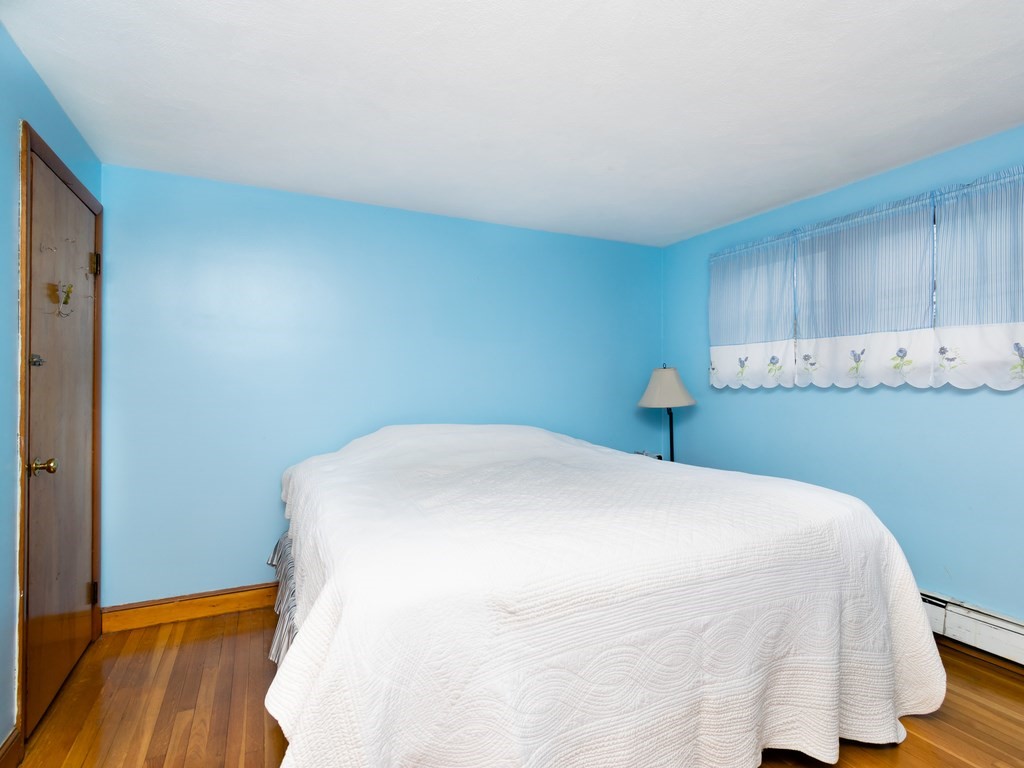 70 Edgemere Road Boston, MA 02132 - Photo 19 of 39 a bedroom with a bed and wooden floor
