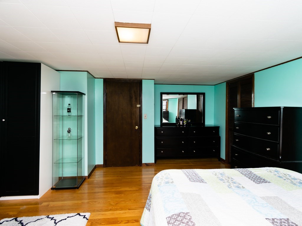 70 Edgemere Road Boston, MA 02132 - Photo 23 of 39 a bedroom with a bed and a dresser