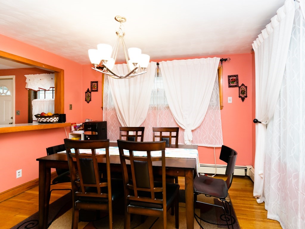 70 Edgemere Road Boston, MA 02132 - Photo 10 of 39 a dining room with furniture a rug and a chandelier