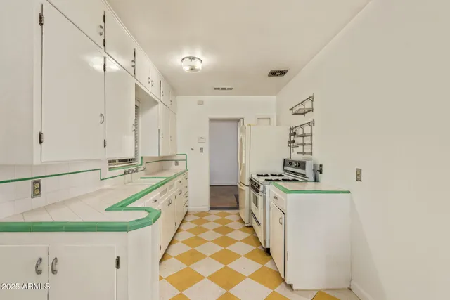 a large white kitchen with a sink and a stove top oven