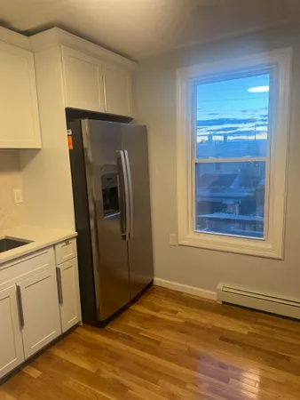 a view of a kitchen with wooden floor and electronic appliances