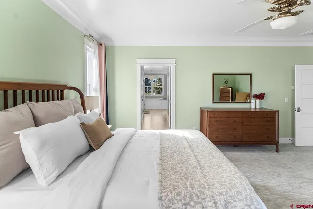 a view of a hallway with wooden floor and a bathroom