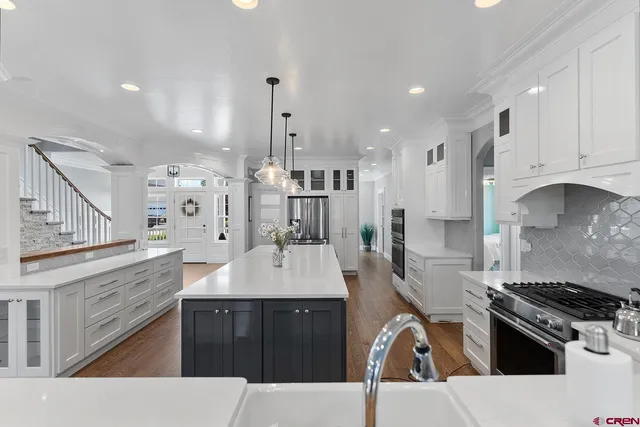 a large kitchen with stainless steel appliances kitchen island granite countertop a stove and a sink