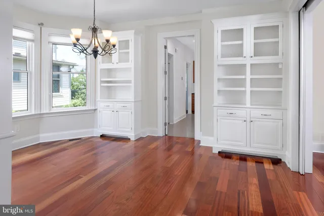 a kitchen with a table chairs sink and wooden floor
