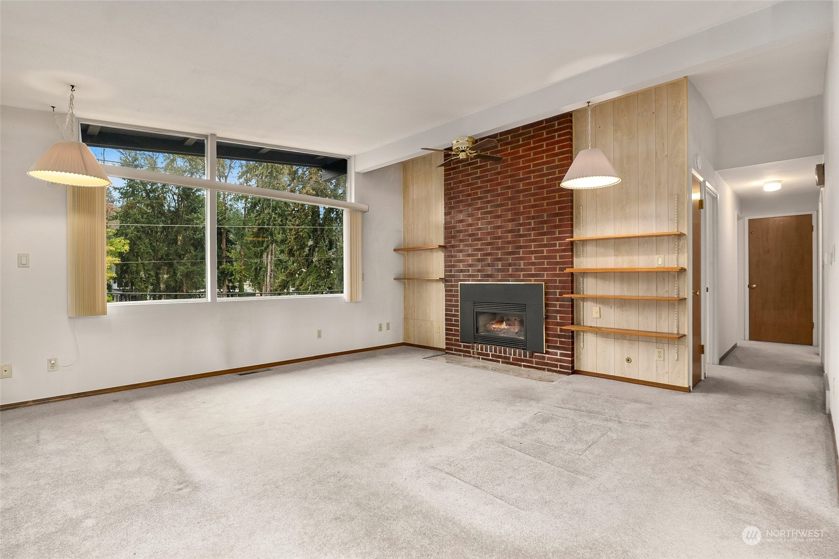 14624 Southeast Allen Rd. Bellevue, WA 98006 - Photo 4 of 26 an empty room with a fireplace cabinet and windows