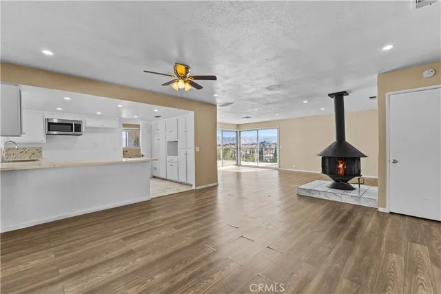 a view of a big room with wooden floor and windows